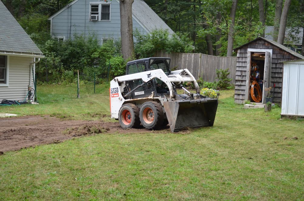 Turf scraped back along a shallow line to expose the path for a French drain trench