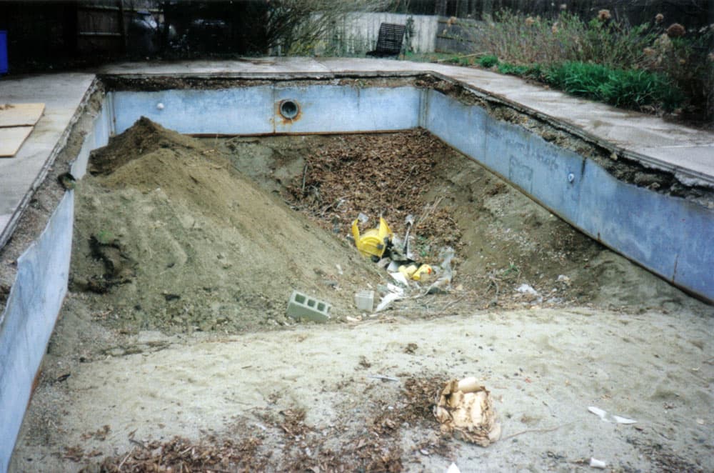 In-ground backyard swimming pool awaiting demolition and backfill removal